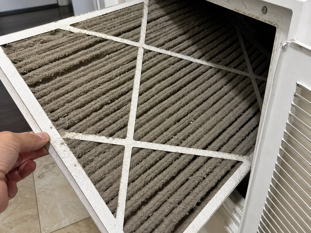Checking an AC filter during a Kissimmee cooling service call